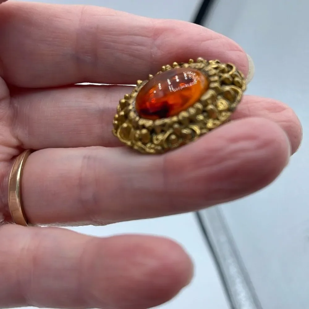 Vintage ornate amber colored brooch.